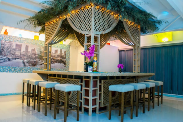 Jacuzzi-bar con bancos altos y barra junto al agua