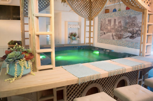 Jacuzzi iluminado con pérgola de madera blanca