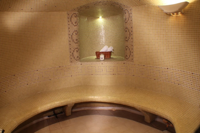 Sauna de vapor de RUSSPA con bancas curvas y mosaico dorado